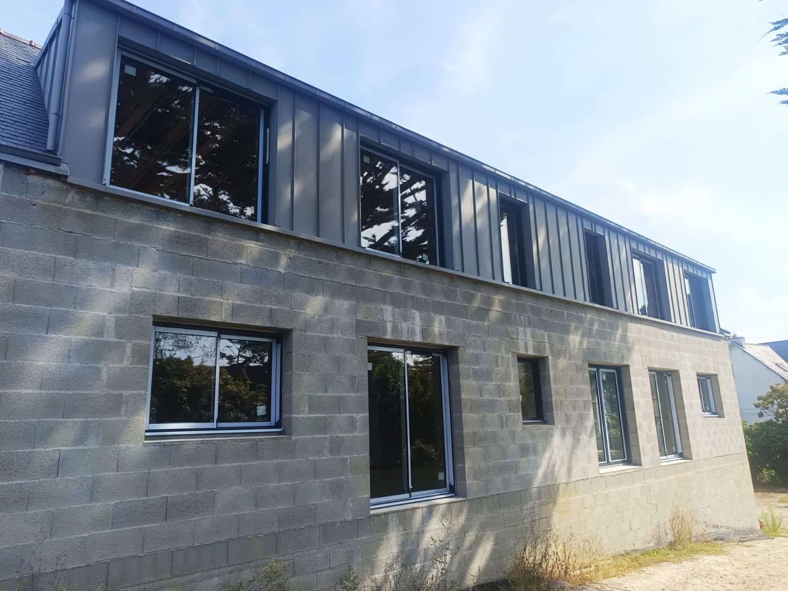 Fenêtres coulissantes aluminium K•Line posées sur une maison en construction vue mer en Finistère Nord Fenêtres coulissantes aluminium K•Line posées sur une maison en construction vue mer en Finistère Nord